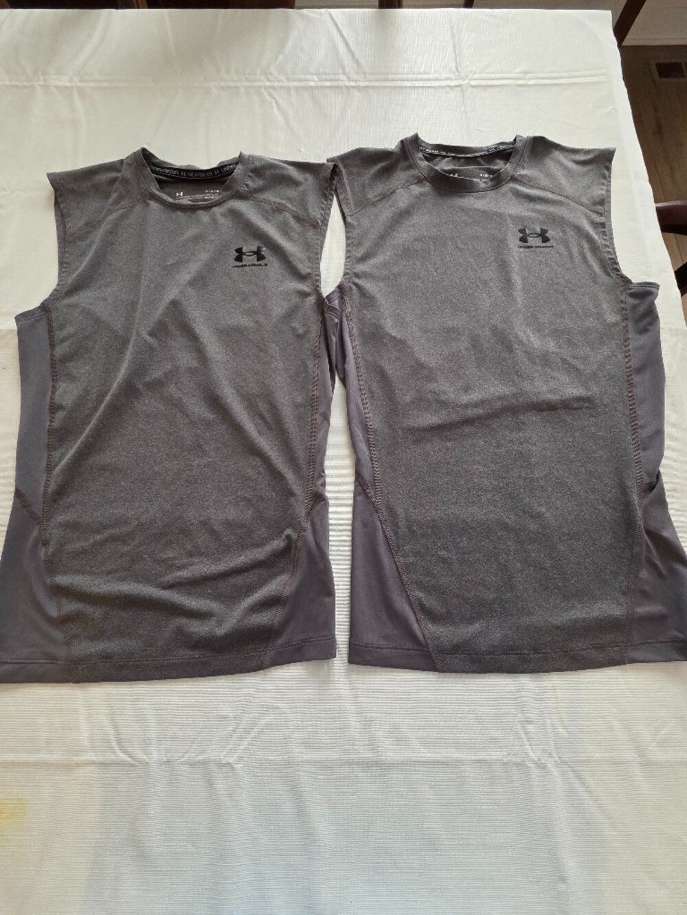 Two UA sleeveless compression shirts, Mens size M